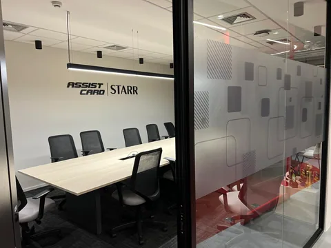 Sala de reunião Assist Card e Starr com identificação e grafismos nos vidros