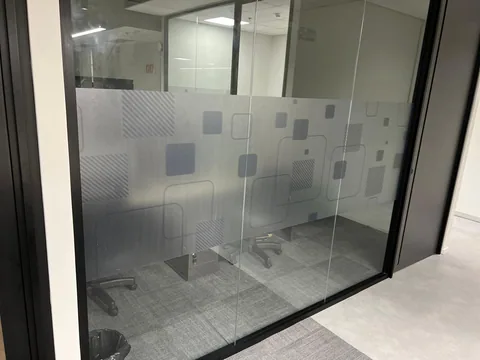 Detalhe de grafismos geométricos jateados aplicados em vidro