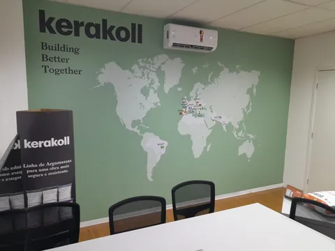 Mapa e identidade Kerakoll aplicados à parede verde de escritório